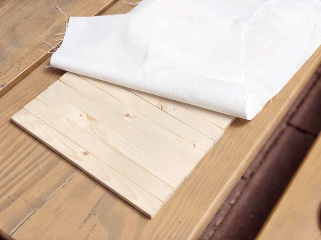 Holzstäbe mit Stoff auf Holztisch