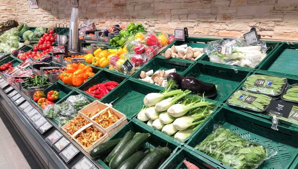 Gemüse unverpackt und in Plastik verpackt im Supermarkt
