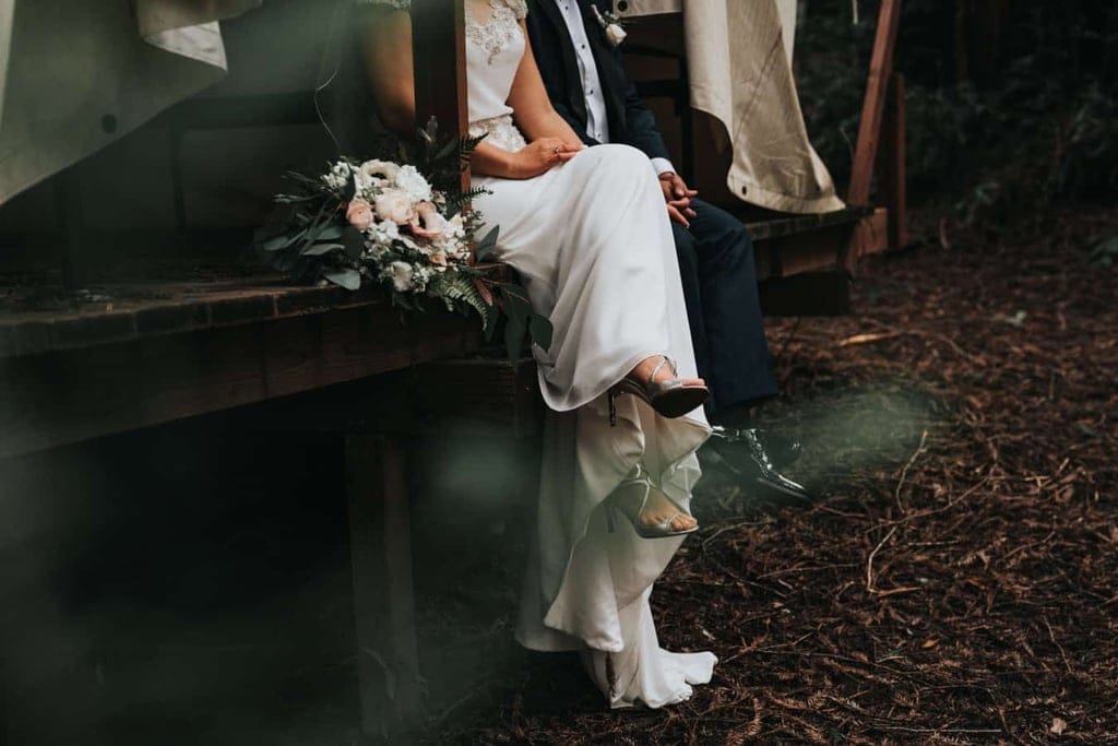 Braut und Bräutigam sitzen auf Holzsteg