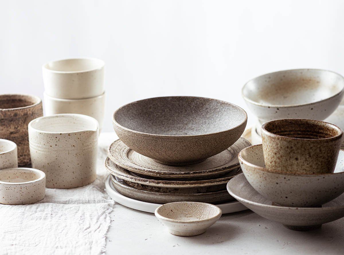 Handgemachte Keramik Teller und Tassen auf weißem Tisch