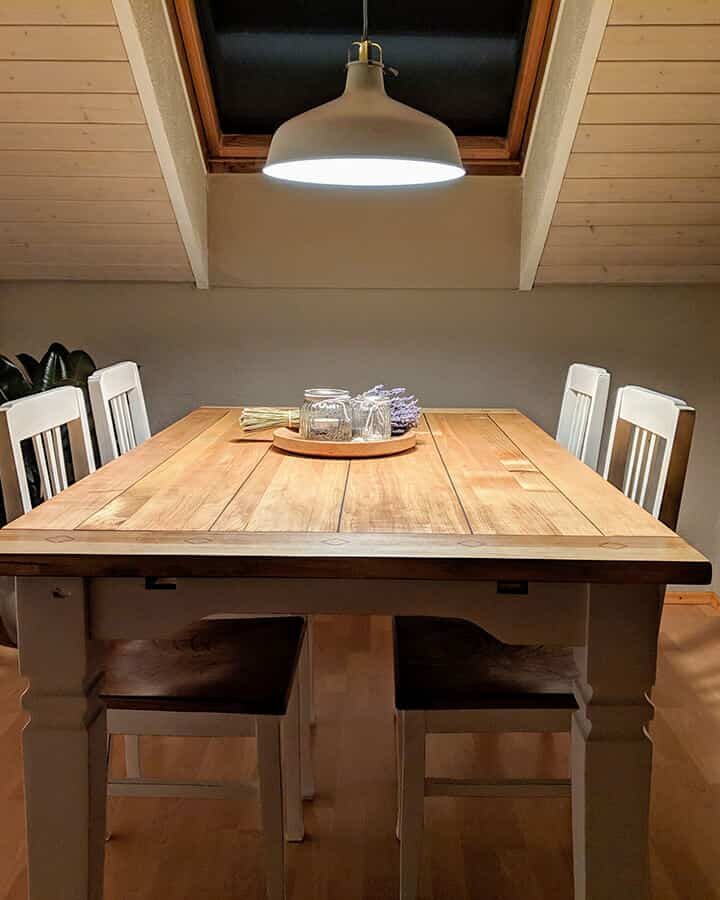 Fertig restaurierter Tisch mit Stühlen und Hängelampe