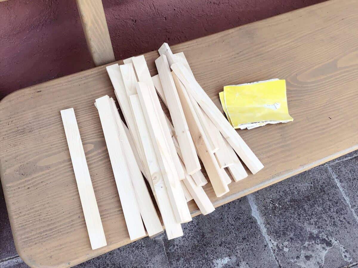 Holzstäbe auf Holzbank mit Schleifpapier