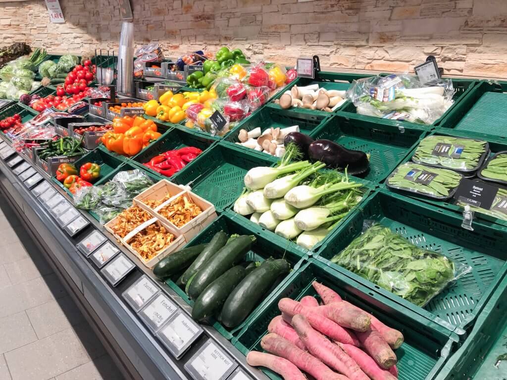 Gemüse unverpackt und in Plastik verpackt im Supermarkt