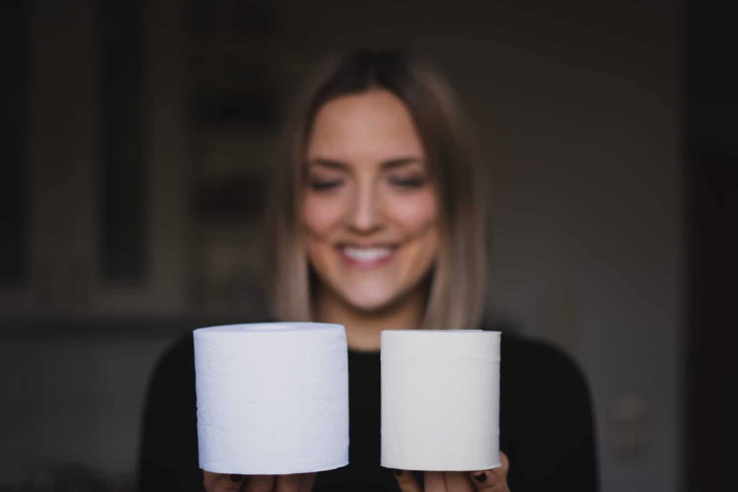 Toilettenpapier aus Holz und Toilettenpapier aus Bambus in Hand gehalten nebeneinander Vergleich