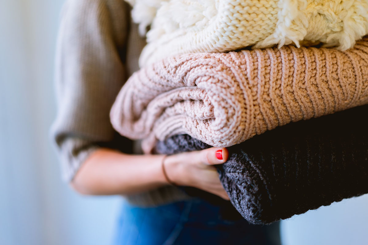 Frau trägt gefaltete Strichpullover