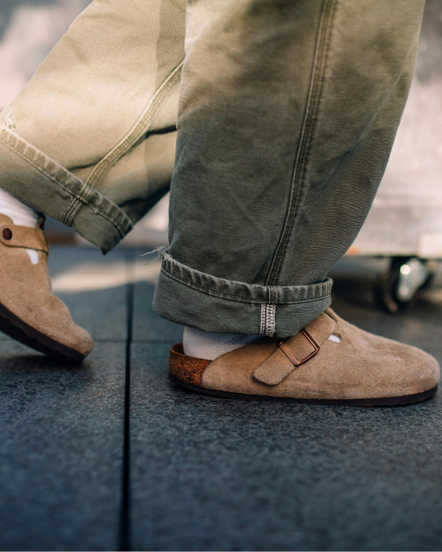 Mann trägt Jeans und Korksandalen