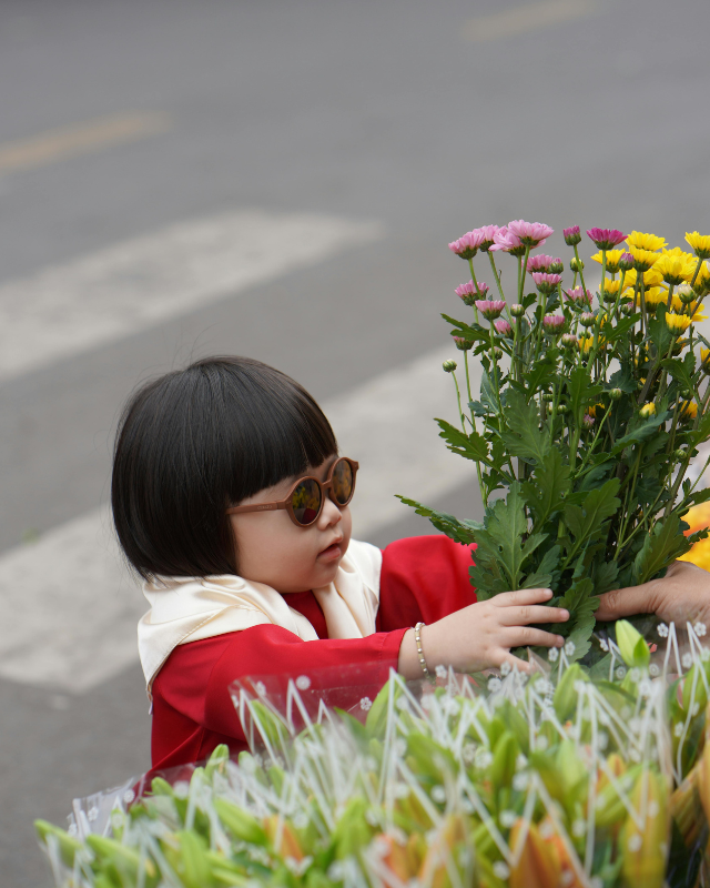 Mädchen mit Sonnenbrille kauft Blumenstrauß