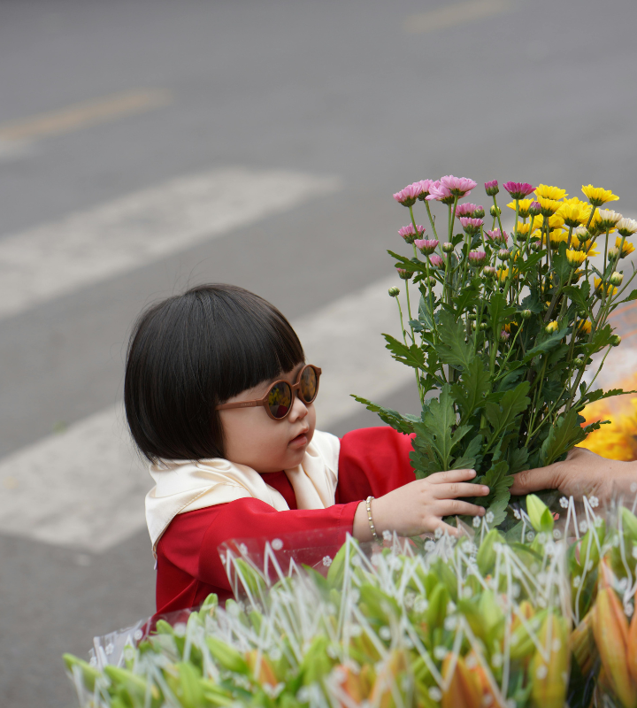 Mädchen mit Sonnenbrille kauft Blumenstrauß